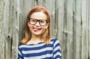 Outdoor portrait of a cute little 9 year old girl wearing eyeglasses