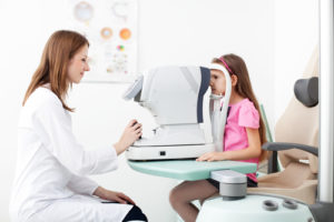Optometrist examines the sight of young girl