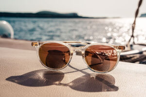 pair of sunglasses next to ocean, protect your eyes from sunlight